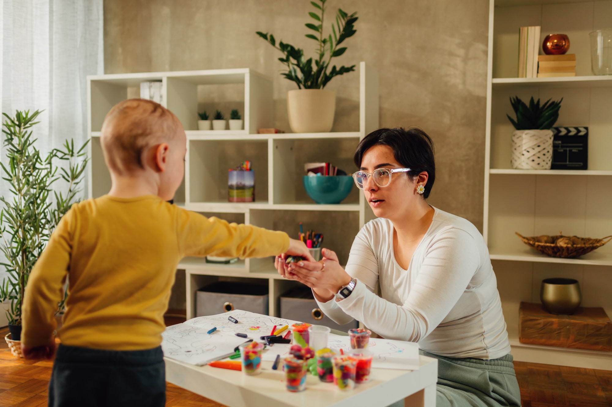 Mother and son drawing with crayons at home